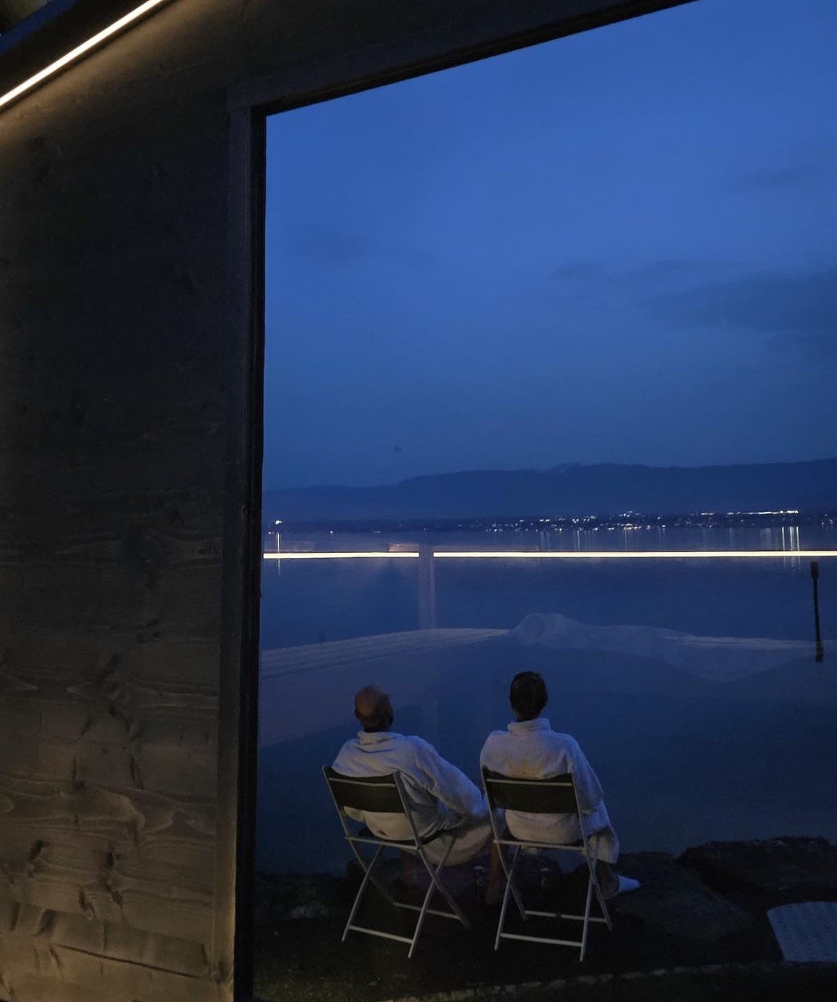 Guests relaxing during a sauna round after a Finnish sauna session at the lakeside sauna in Anières on Lake Geneva.